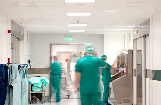 Blurred figures of people in medical uniforms in hospital preparing for operation