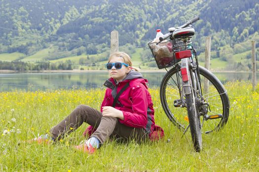 young girl with the bike in the mountains