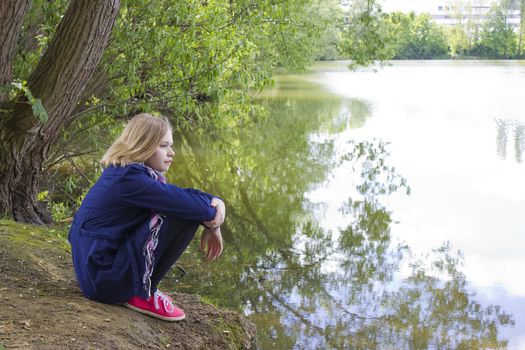  little girl sitting by the water 