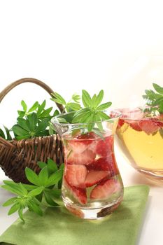 May wine with fresh strawberries and woodruff on a light background