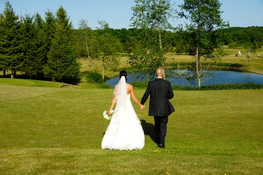 Wedding couple are walking in park.