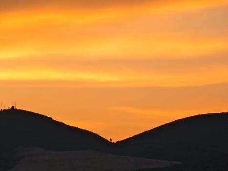 brightorange sunset with mountains in shadow