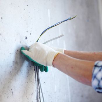 worker puts the wires in the wall