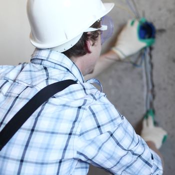 worker puts the wires in the wall