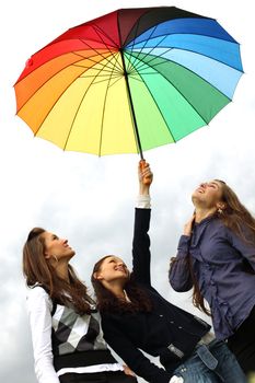 girlfriends stay under colourful umbrella 