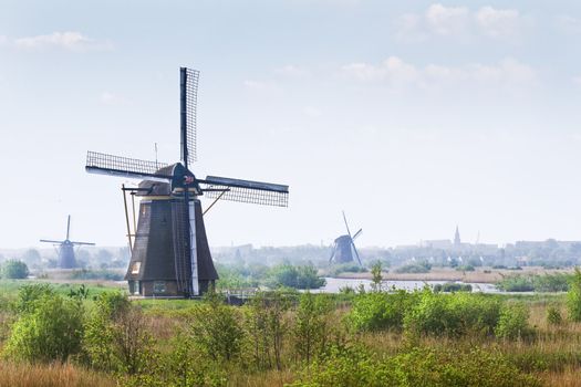 Country landscape with windmills at Kinderdijk, the Netherlands on hazy day in spring
