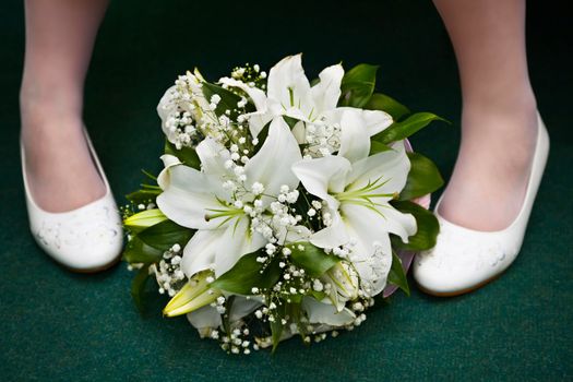 Bridal bouquet and the bride's feet in shoes