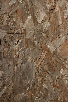 A background of wooden composite board with texture and multicolours.