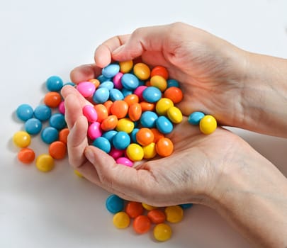Woman hands is holding colored candy