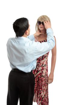 Salesman dresses a mannequin for a department or boutique clothing store.  White background.
