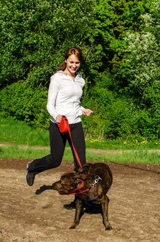 Woman walking with an American Stafford in the park