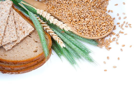 tasty baked bread with ears and wheat grain, isolated on a white background