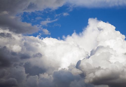 cumulus clouds soaring on the dark blue sky