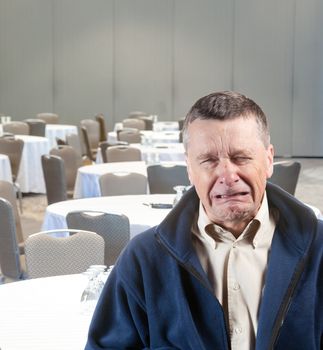 Senior male weeping in empty meeting room workplace harassment