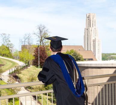 Doctoral graduate looking toward Cathedral of Learning at University of Pittsburgh
