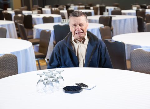 Senior male weeping in empty meeting room workplace harassment