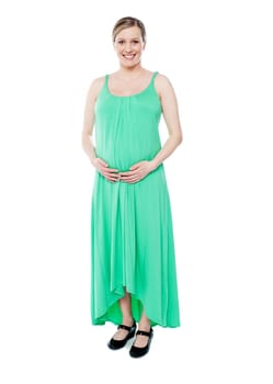 Gorgeous brunette pregnant woman dressed like princess in green fashionable outfit