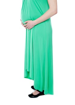 Pregnant lady expecting baby wearing green dress. Fashion outfit