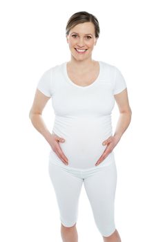 Photo of pregnant woman holding her tummy isolated over white background