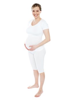 pregnant woman caressing her belly over white background