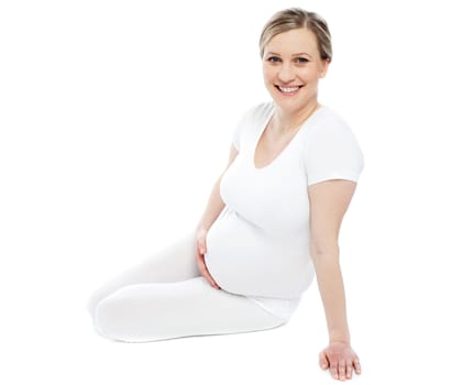 Studio portrait of pregnant woman dressed in white. Isolated