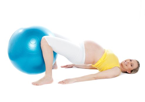 A young pregnant woman doing relaxation exercise using a fitness ball