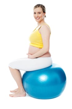 Pregnant woman sitting on gymnastic ball isolated on white background