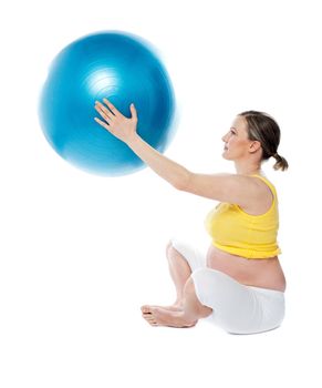 Attractive pregnant lady practicing yoga with gymnastic ball isolated over white