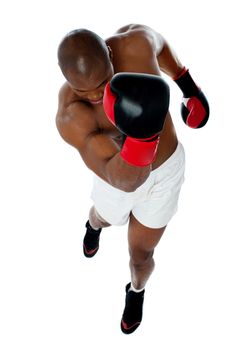 A black african american man athletic boxer with boxing gloves punching in upwards direction