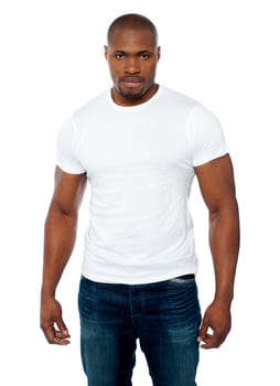 Casual muscular african young man looking right into camera against white background