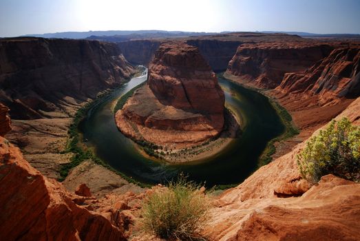 the colorado river curves around a canyon as the famous horseshoe bend
