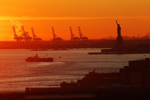 statue of liberty from new york during sunset