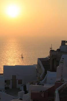 Beautiful sunset and boat at Oia village, Santorini, Greece