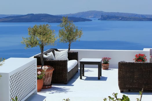 View on the volcano and Aegean sea from a balcony with furnitures at Oia, Santorini island, Greece