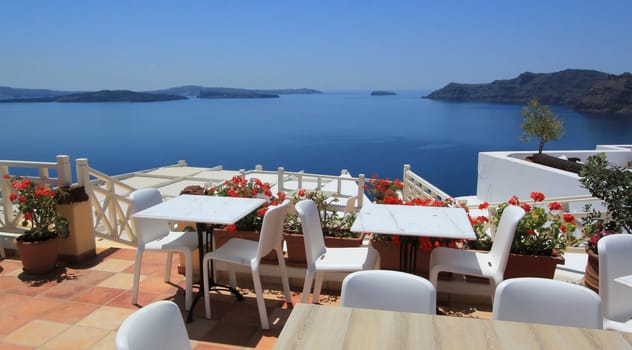 View on the volcano and Aegean sea from a restaurant balcony with at Oia, Santorini island, Greece