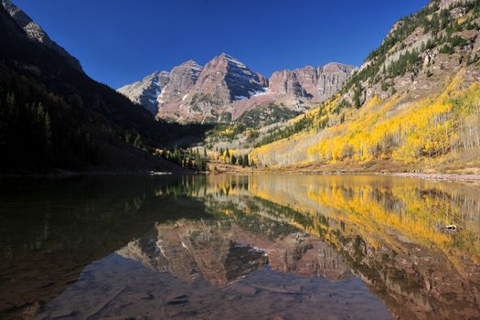 a reflection of mountain with yellow tree in autumn, from Maroon Lake, colorado
