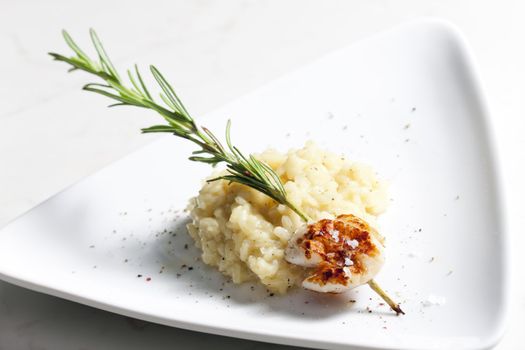 grilled Saint Jacques mollusc on rosemary needle with risotto