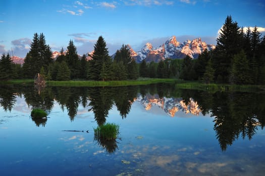 Grand Teton Mountains in Yellowstone with their reflections in the morning sunrise