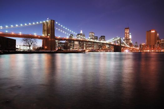 A famous Brooklyn Bridge at night with a deep blue sky after sunset