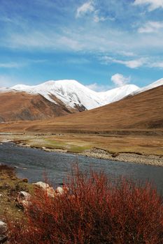 Landscape of snow-capped mountains and a river in the highland of Tibet