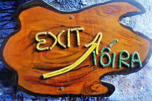Exit sign made of rope on a piece of wood