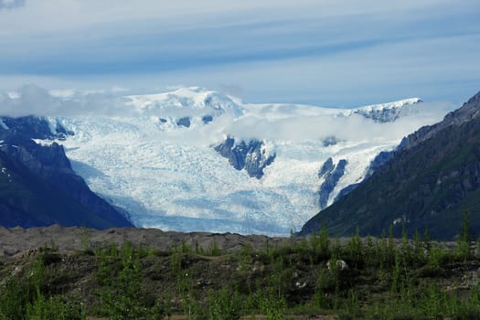 Root Glacier from Alaska surrounding with mountains and clouds