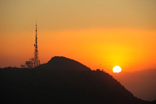 sunset over mountains with radio station