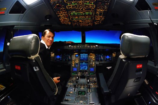 captain was sitting in airbus A330 plane cockpit with many controllers and switches