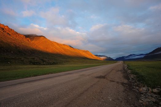the famous long haul road called Dalton Highway from Alaska. It's a unpaved road from Fairbanks to Aictic circle. Mountain was lighten from midnight sun