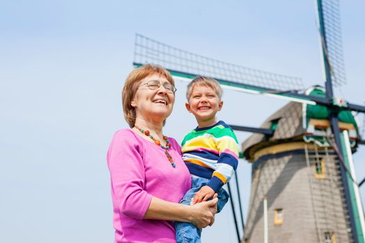 Grandother and grandson near windmill in Holland