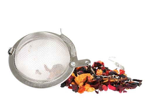 Metal tea strainer with heap of fruit tea on white background