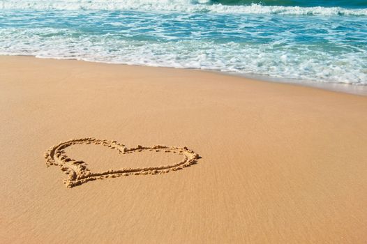 Heart drawn on beach sand, summer love