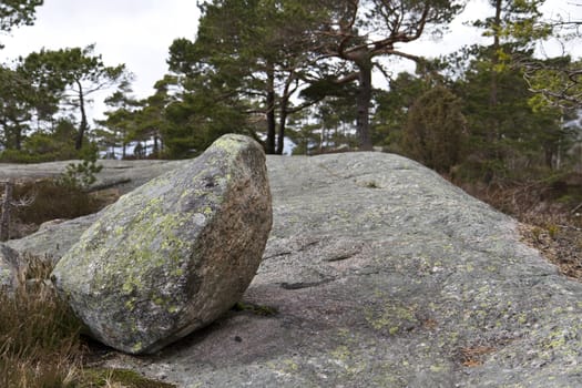 big stone laying on bigger once in landscape of norway