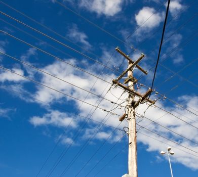 power lines for australian power pole electricity grid against cloudy blue sky